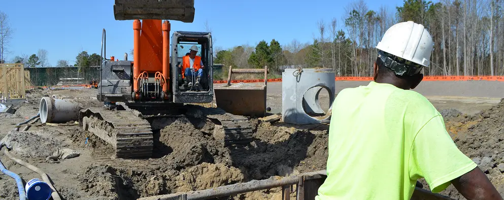 Excavator and workers on construction site