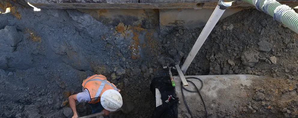 Construction worker digging in a trench
